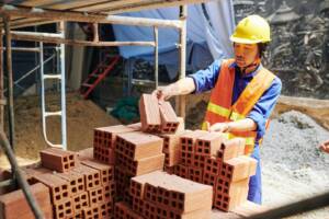 Builder taking orange bricks